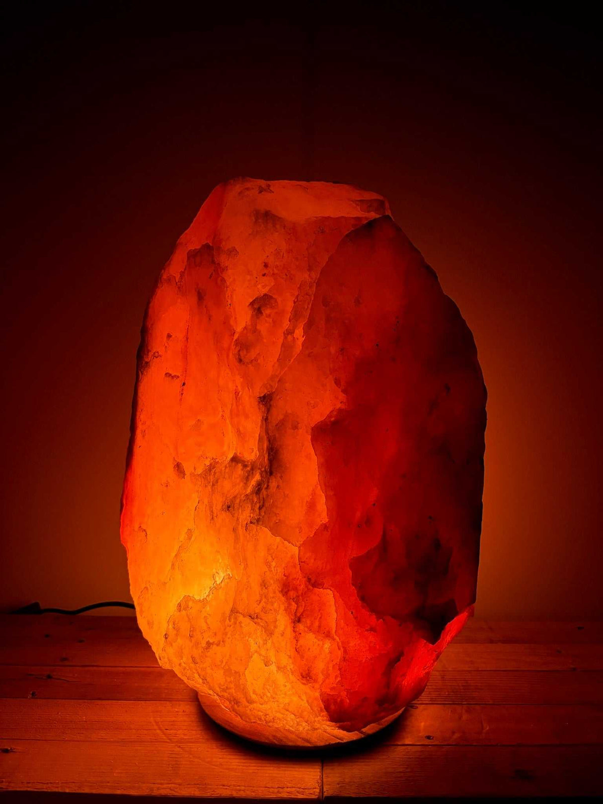 Himalaya zoutlamp rood 45-50 kg met warme, diepe gloed en houten voet, inclusief kabel en reservelampje.