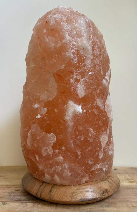 Grote Himalaya zoutlamp 10-12kg op houten voet, sfeerlicht en luchtzuivering voor woonkamers.