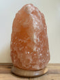 Himalaya zoutlamp 12-15kg, middelgroot  formaat met warme, natuurlijke gloed, op stevige houten voet.