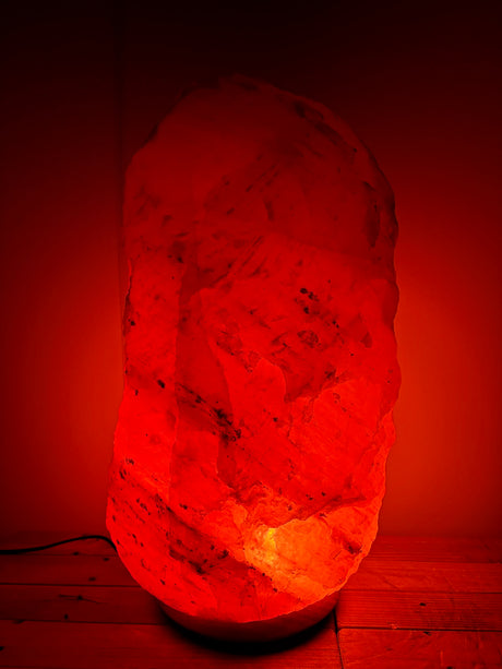 Grote Himalaya zoutlamp 30-35kg op houten voet, sfeervolle natuurlijke luchtzuiveraar voor woon- of bedrijfsruimte.
