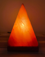 Handgemaakte Himalaya zoutlamp piramidevorm met houten voet en warme gloed