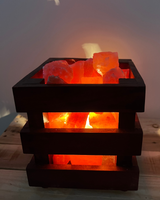 Vierkante houten mand gevuld met zoutsteenbrokken, inclusief lamp en schakelaar voor warme, sfeervolle verlichting.