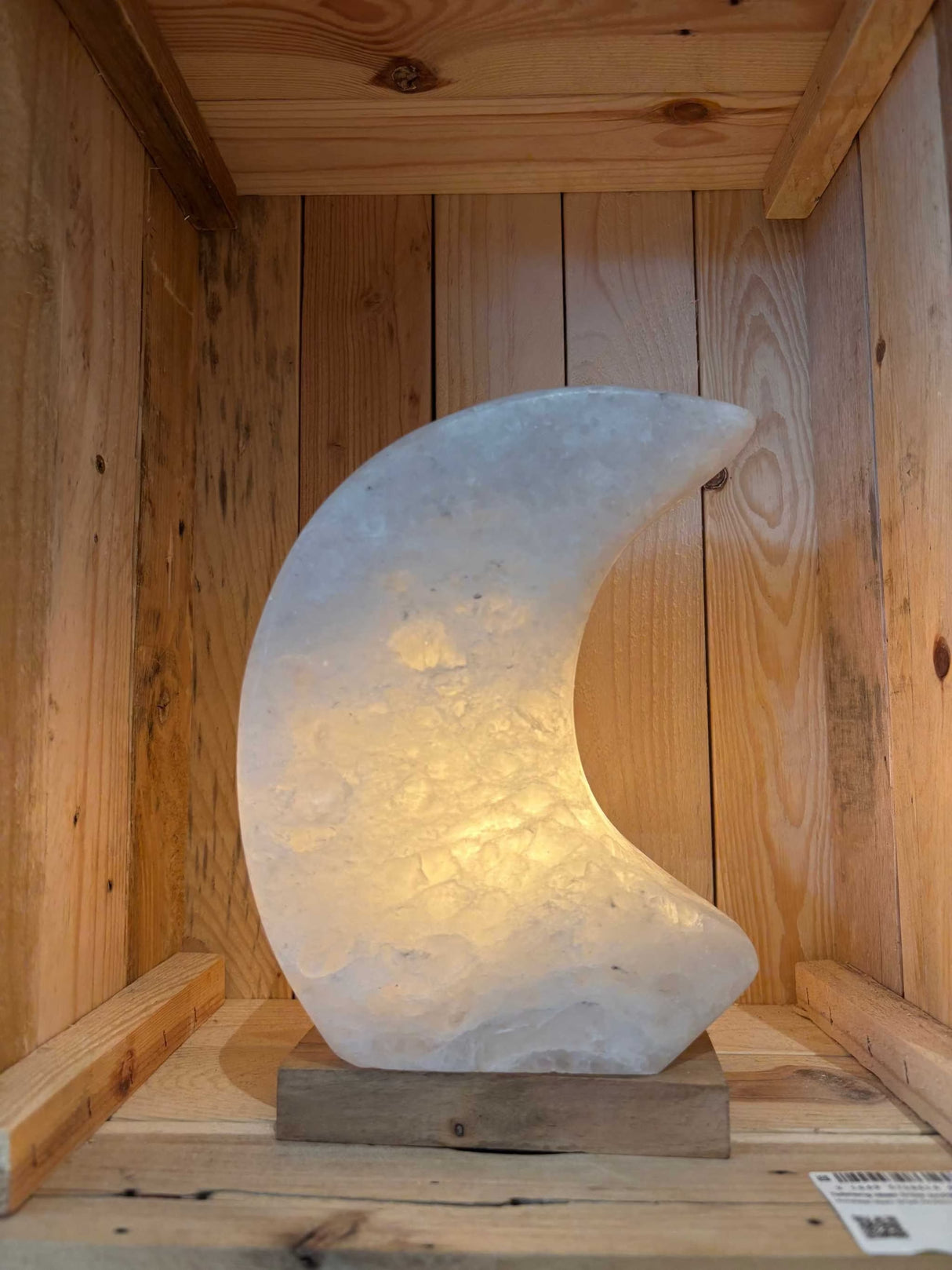 Maanvormige Himalaya Zoutlamp in roze, grijs en wit met warme gloed en houten voet.