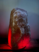 Himalaya XL zoutlamp rood van 120-140 kg met warme oranje-rode gloed en houten voet
