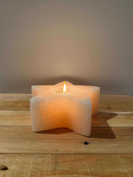 Handgemaakte stervormige waxinelichthouder van natuurlijke zoutsteen met warm gloeiend licht