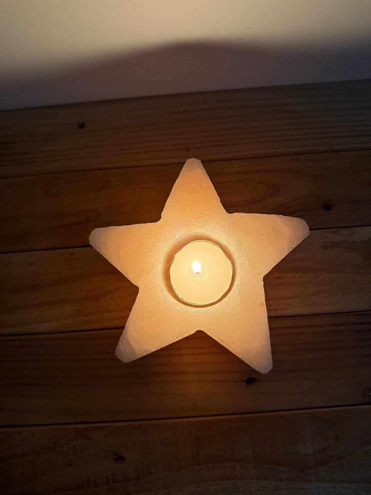 Handgemaakte stervormige waxinelichthouder van natuurlijke zoutsteen met warm gloedlicht