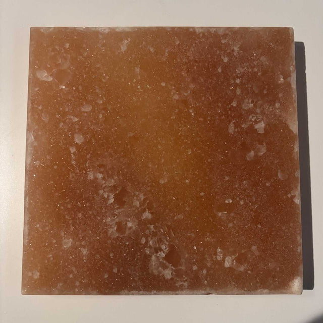 Massieve vierkante Himalaya zoutsteen tegel 20x20 cm met unieke kleurvariaties uit Khewra, ideaal als wandpaneel of sfeerverlichting.